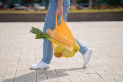 femme qui marche avec sac de légumes